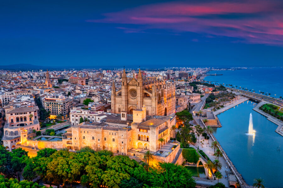 The majestic Cathedral La Seu in Palma de Mallorca, bathed in the golden light of sunset, creating a stunning skyline.