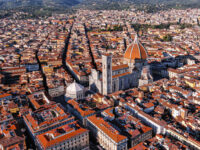 Aerial view of the Cathedral of Santa Maria del Fiore in Florence, showcasing its iconic red-tiled dome and surrounding architecture