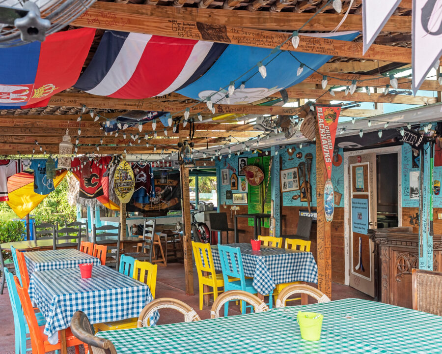 Patio at the Czech Inn restaurant in Bodden Town, Grand Cayman, with outdoor seating and tropical foliage.