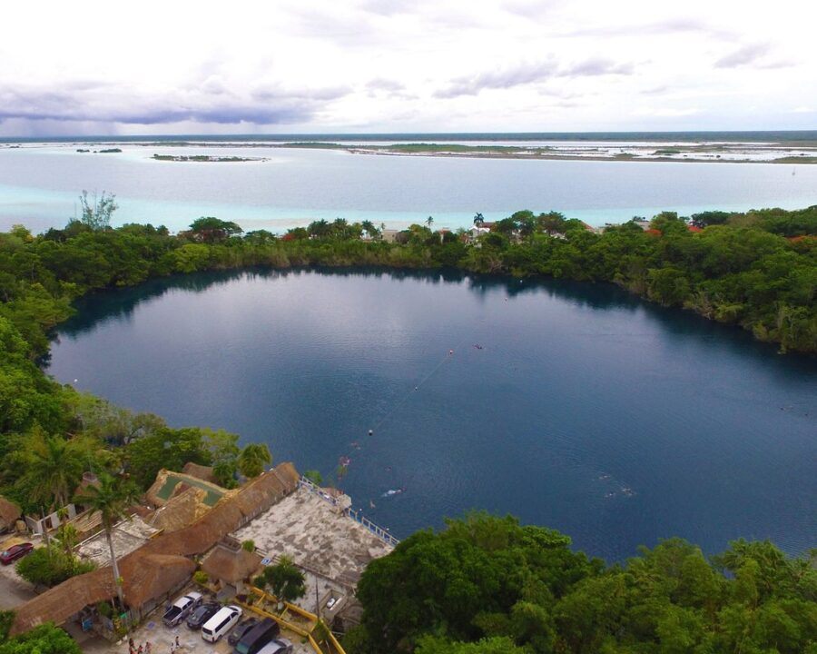 Aerial view of Cenote Azul Bacalar, a lake surrounded by lush trees in Quintana Roo, Mexico.