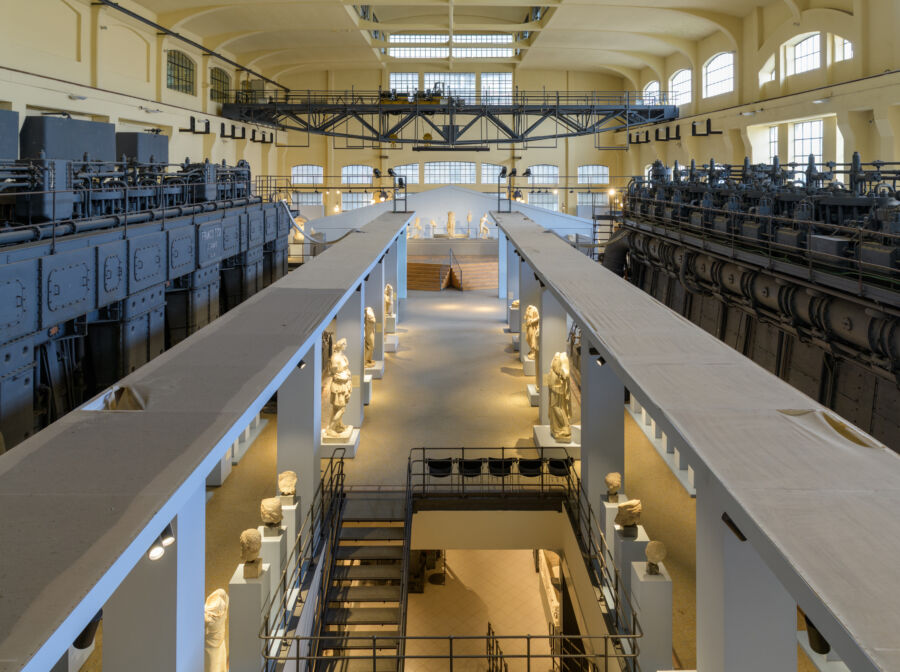 Interior view of the Centrale Montemartini museum's Engine Room, showcasing industrial machinery and classical sculptures