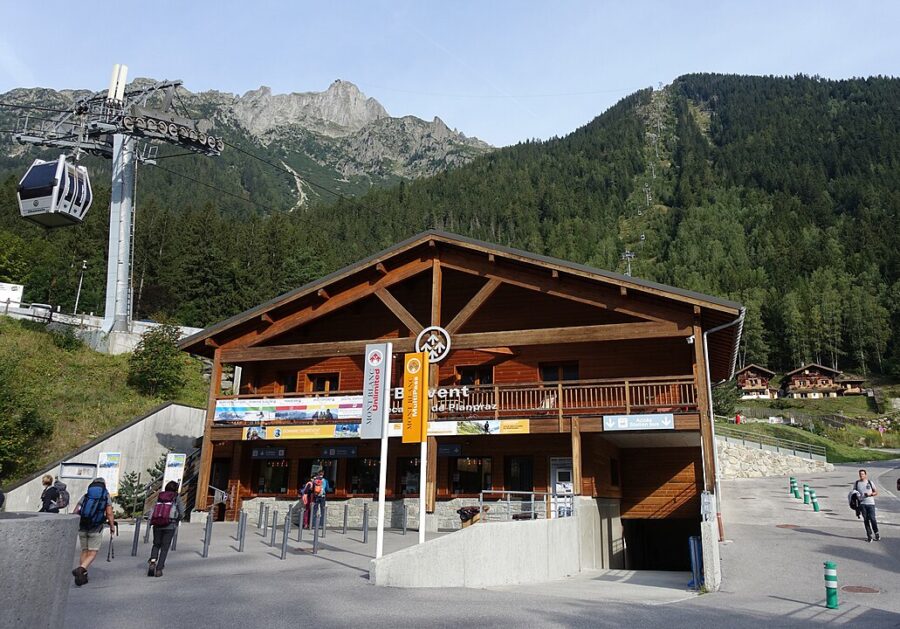 The Chamonix Planpraz Lift on a snowy mountain, with a building visible at the base, under a bright sky.
