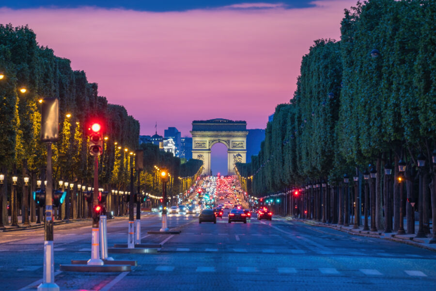 Night view of Paris skyline featuring the Arc de Triomphe and the illuminated Champs-Élysées