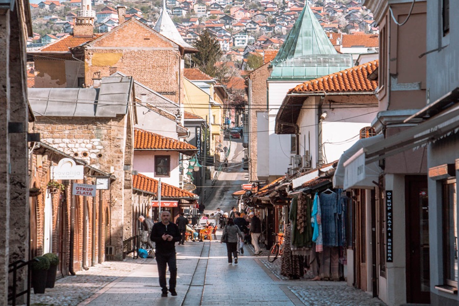 Quaint street scene with diverse architecture in Baščaršija district adorned by terracotta rooftops.