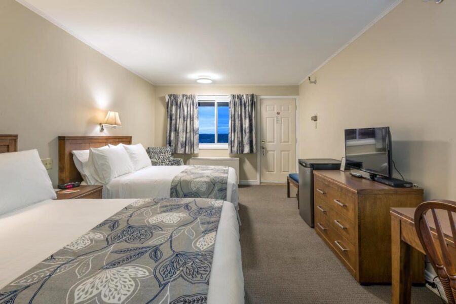 Two beds in a hotel room at Chebucto Inn, Halifax, with a television and a desk visible in the background.