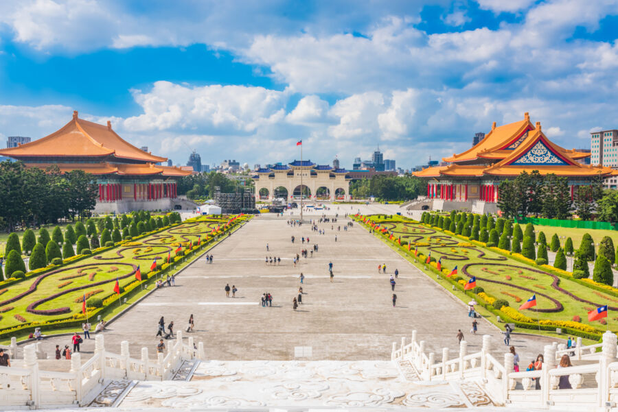 The Chiang Kai-shek Memorial Hall in Taipei, Taiwan, showcases a large white building with a blue roof and landscaped grounds