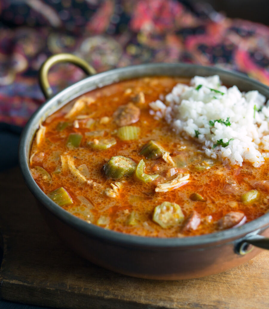 Close-up of chicken gumbo served in a bowl, featuring a scoop of white rice on top