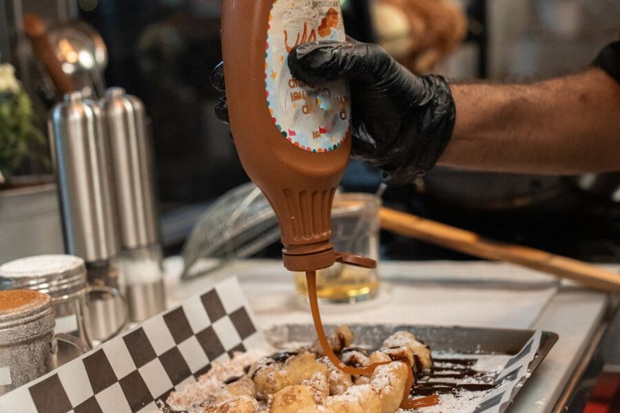 Chocolate sauce poured on churros with powdered sugar, creating a delicious dessert scene.