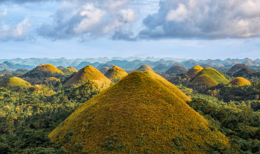 Aerial view of the iconic Chocolate Hills on Bohol Island, showcasing their unique conical shapes and lush green surroundings.