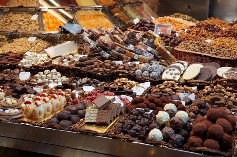 Assorted chocolate truffles and bonbons display at a market stall.
