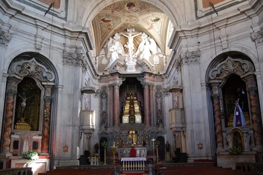 Igreja de Santo Estêvão baroque church interior with ornate high altar and crucifixion sculpture.