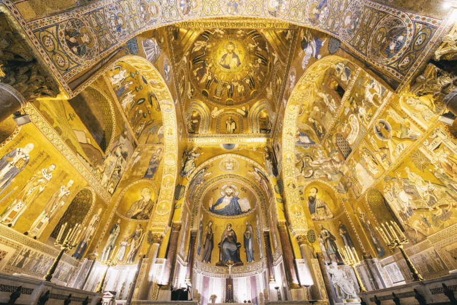 Golden mosaics and frescoes adorned church interior with arches and religious icons.