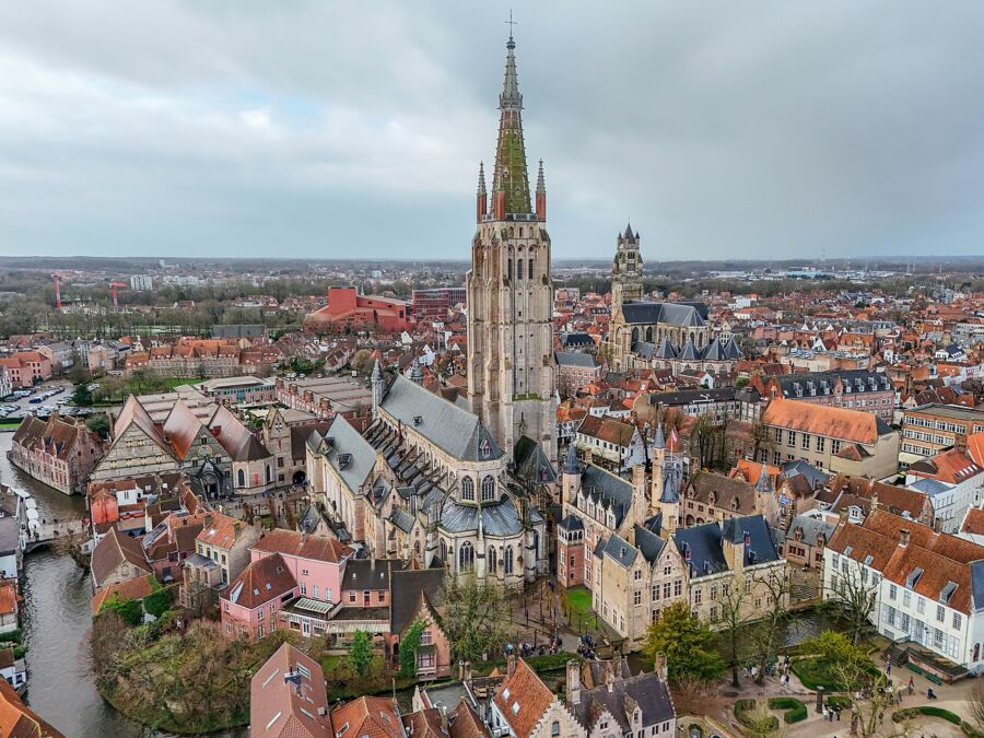 Aerial view of Bruges, Belgium, showcasing the Church of Our Lady and surrounding historic cityscape.