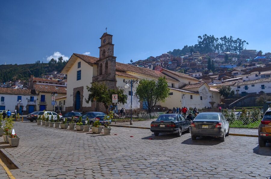 Parked cars line the street in front of the Church of San Blas, located in Plaza San Blas, Cusco, Peru.