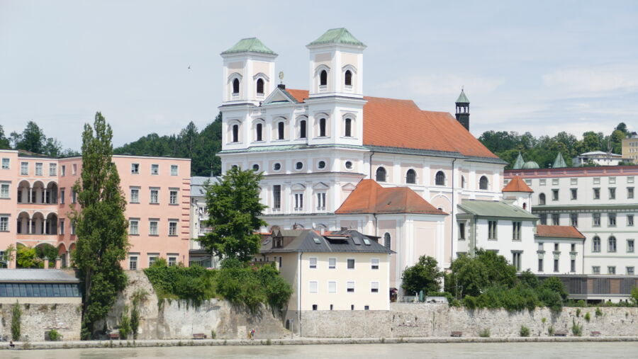 Exterior view of the Church of St. Michael with the skyline of Passau, Germany, showcasing its architectural features