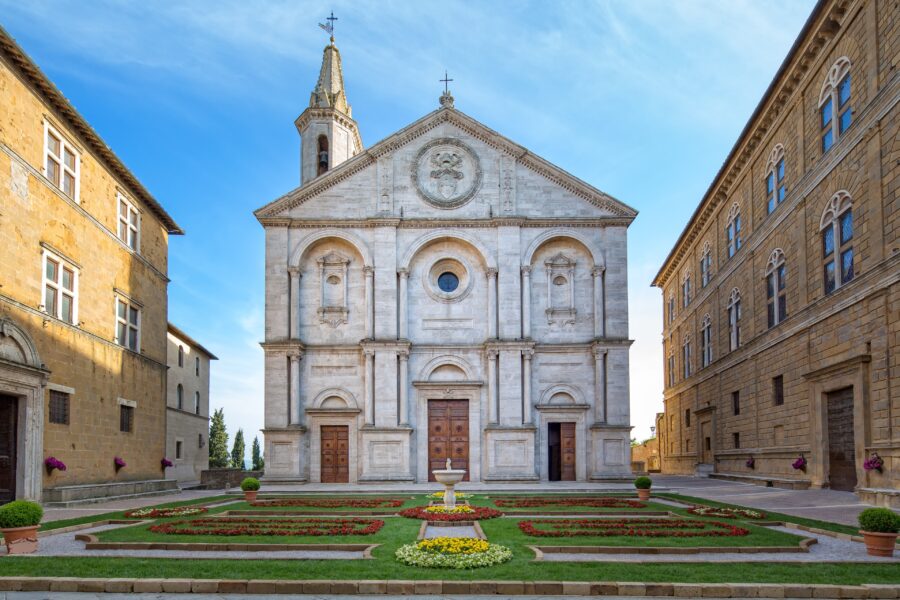 Historic Pienza square with elegant church, colorful gardens, and harmonious classical architecture.