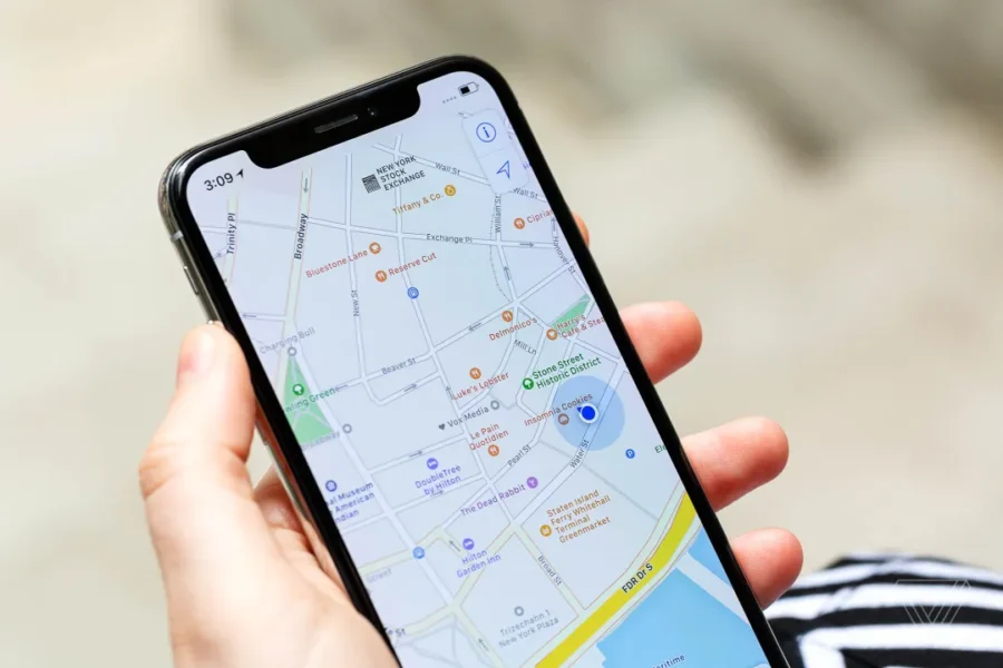 Close-up of smartphone map displaying New York landmarks and navigation in urban setting.