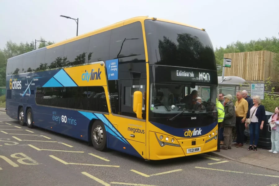 Blue and yellow Citylink double-decker bus in Edinburgh with passengers boarding.