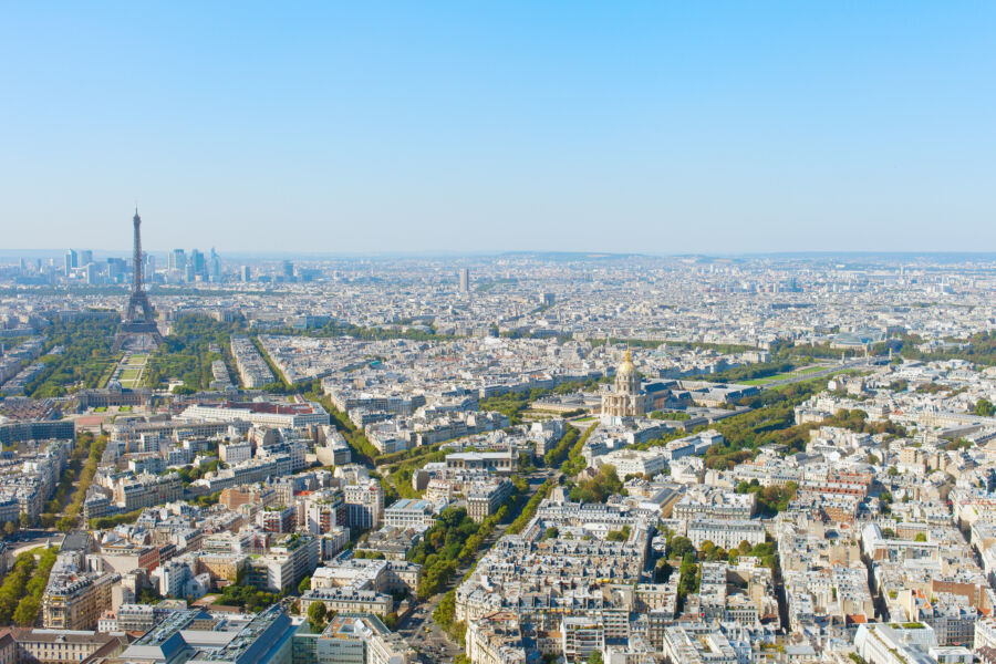 Bright cityscape of Paris featuring iconic buildings under a clear blue sky on a sunny day
