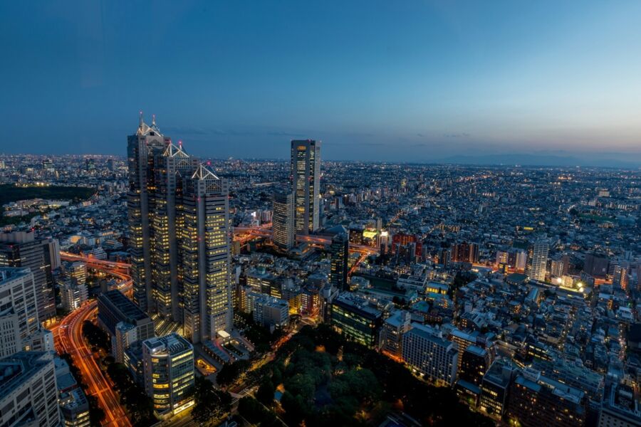Twilight urban skyline view with skyscrapers and city lights reflecting in glass façades.