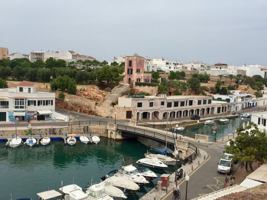Scenic view of Ciutadella harbor in Menorca, featuring numerous boats docked along the waterfront.