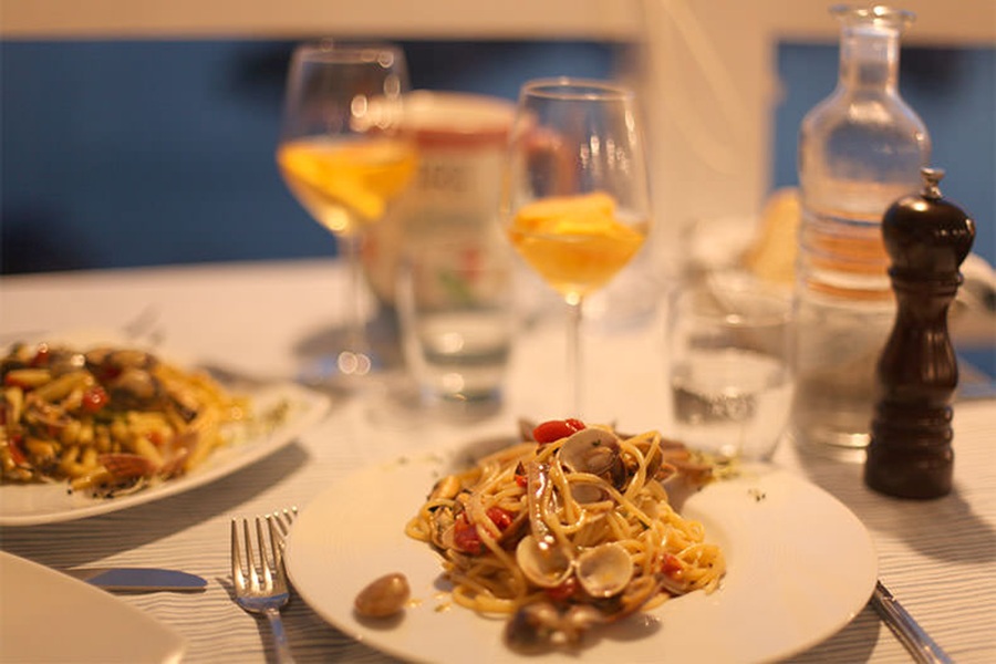 Spaghetti with clams, cherry tomatoes, seafood pasta dinner with wine.