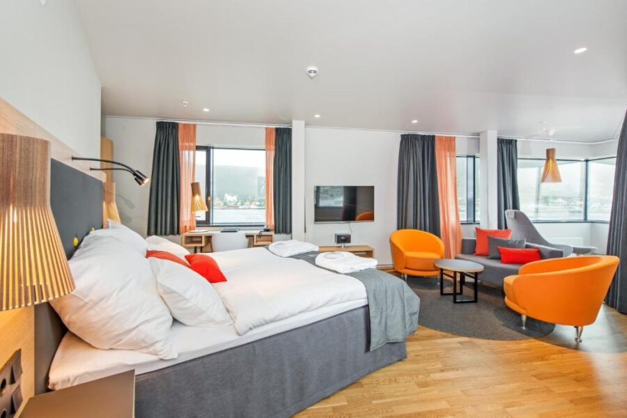 Hotel room at Clarion Hotel The Edge, Tromsø, featuring modern decor with orange and white accents.
