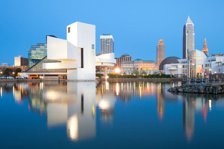 Cleveland harbor cityscape featuring skyscrapers, boats, and the waterfront, with a vibrant atmosphere and clear skies