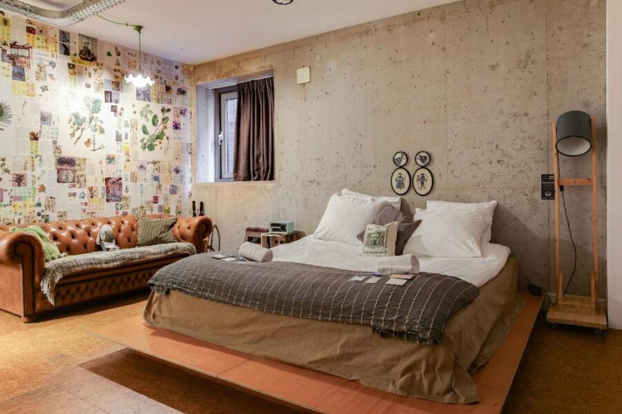 Stylish bedroom with a bed, a couch, and a picture-covered wall, located in ClinkMama, Amsterdam.