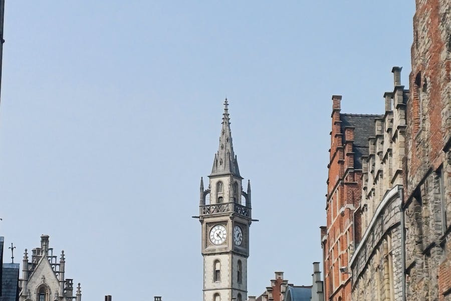Historic Ghent belfry clock tower with stone facades and stepped gables.