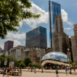 Cloud Gate Sculpture in Chicago, Illinois, with tourists and locals admiring its reflective surface and unique design