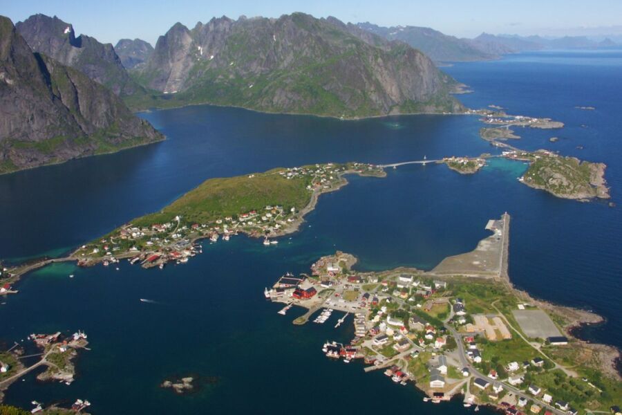 Aerial view of Norwegian archipelago with scenic islands, colorful village, and vibrant coastline.