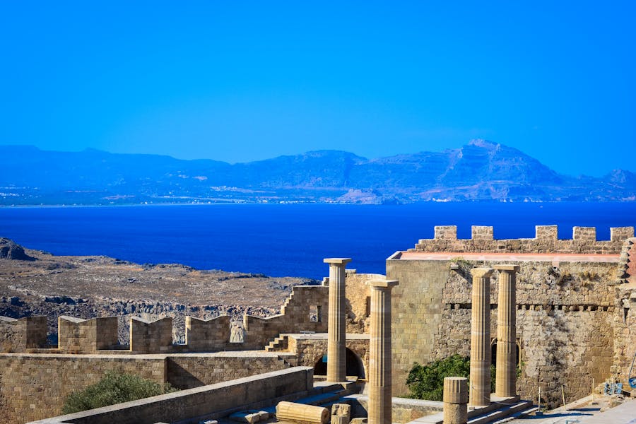 Ancient coastal ruins with columns and panoramic sea view.