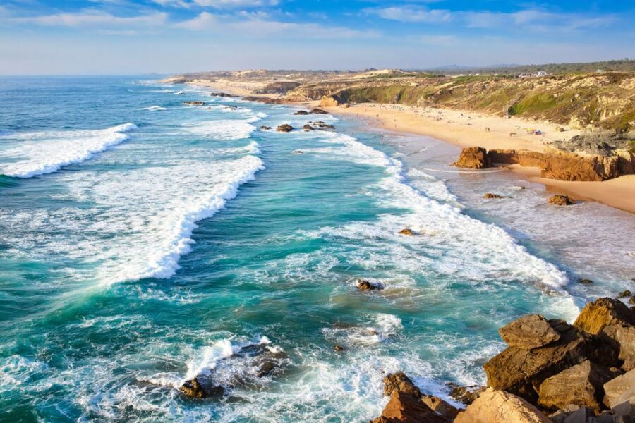 Aerial view of Alentejo coast, Portugal: sandy beaches, rocky headlands, rolling Atlantic waves.