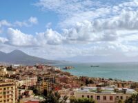 Aerial view of Naples, Italy with Mount Vesuvius, Mediterranean Sea, and vibrant architecture.