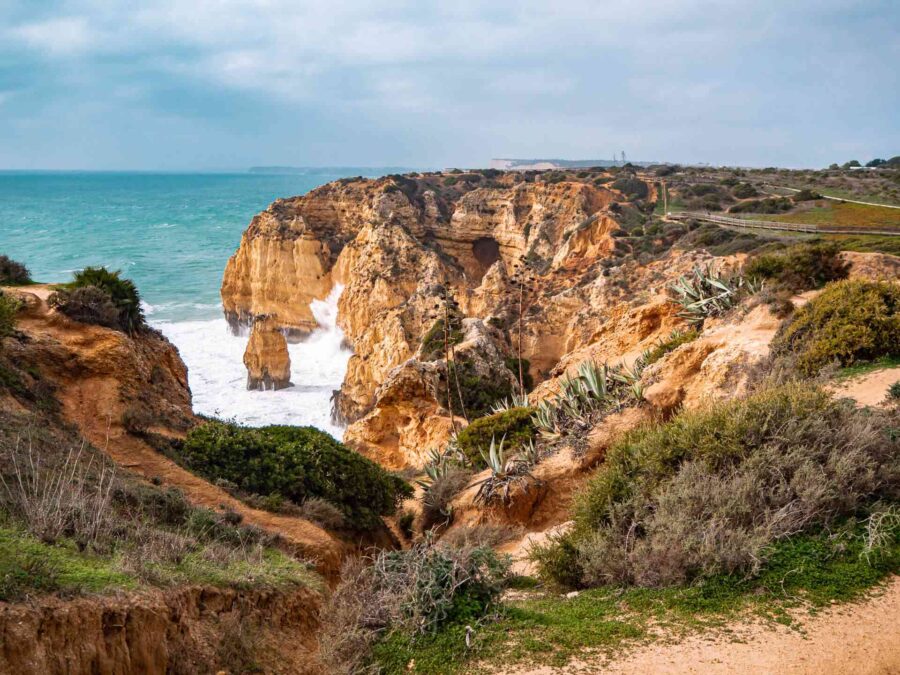 Algarve coastal cliffs, sea stacks, and turquoise Atlantic Ocean in Portugal.