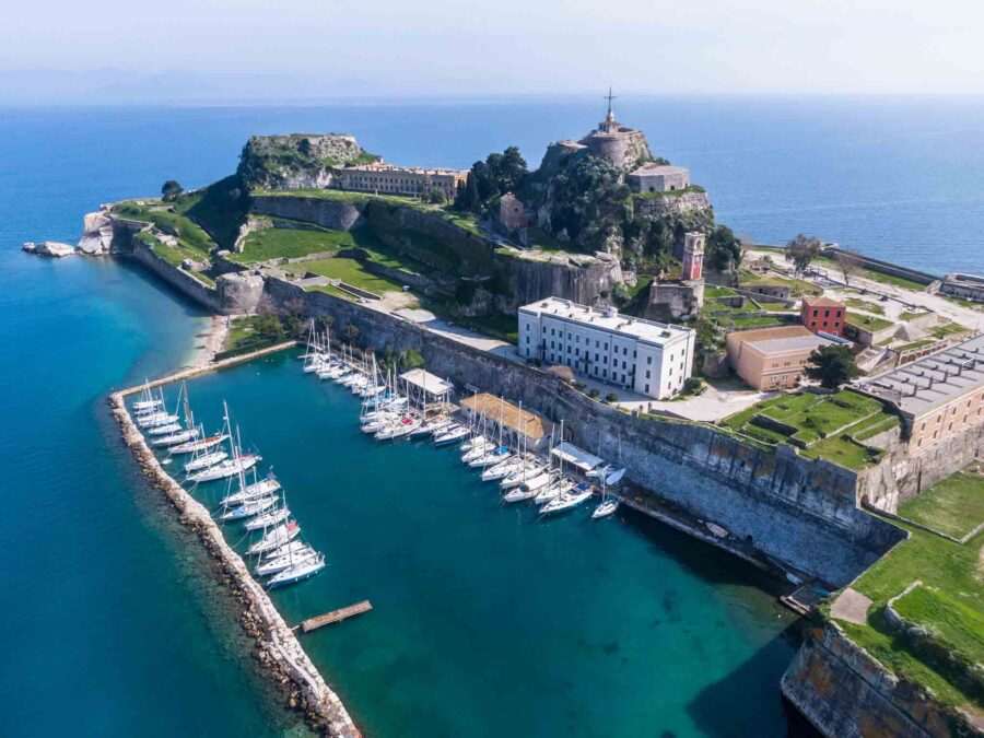 Aerial view of Corfus historical coastal fortification, marina, and Mediterranean Sea.