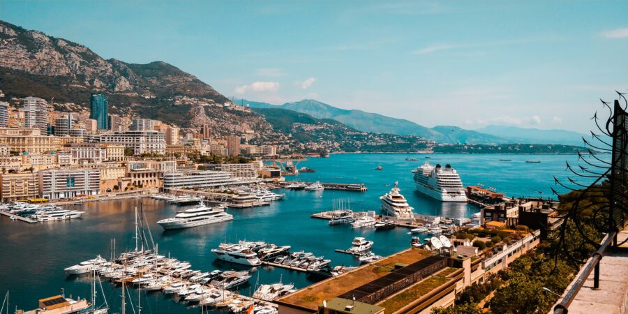 Monte Carlo, Monaco marina with luxury yachts and coastal city skyline.