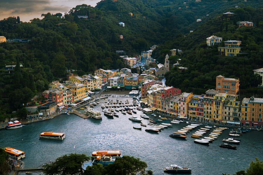 Colorful Portofino harbor in Liguria, Italy, with moored boats and waterfront buildings.