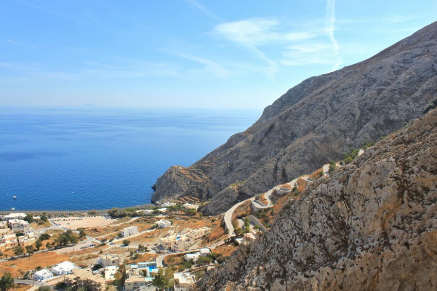 Stunning coastal landscape with cliffs, azure sea, and quaint Mediterranean village.