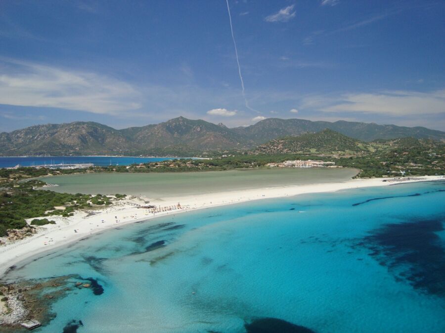 Pristine beach, turquoise waters, scenic mountains, perfect blue sky, tranquil coastal paradise.