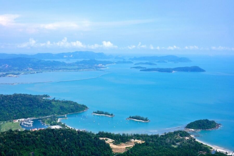 Aerial view of tropical islands, azure ocean, boats, and lush vegetation.