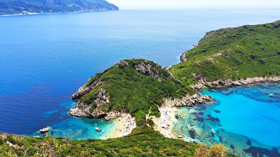 Breathtaking Porto Timoni bay with clear waters, lush hills, and sandy beaches.