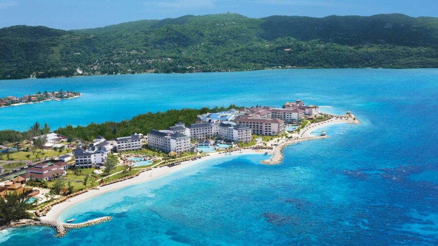 Luxurious coastal resort with stunning ocean views and lush green hills.