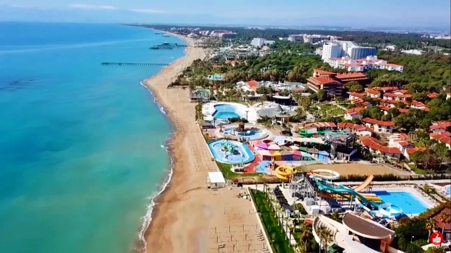 Aerial view of Belek Turkey beach resort with water park, hotels, pools and Mediterranean coast.