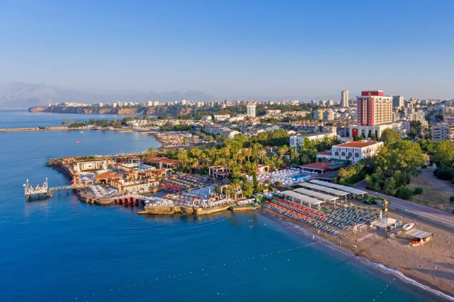 Aerial view of Lara Beach Antalya resort city coastline with hotels, pools, and Mediterranean sea.