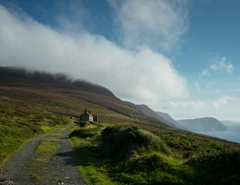 Remote coastal stone cottage on hillside along Raad ny Foillan walking trail, Isle of Man.