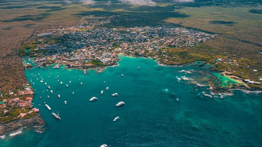 Aerial view of coastal town with turquoise waters and lush greenery.