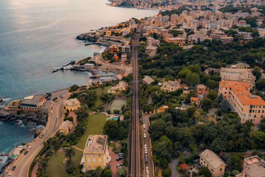 Aerial view of a coastal town with stunning coastline, lush greenery, and diverse architecture.