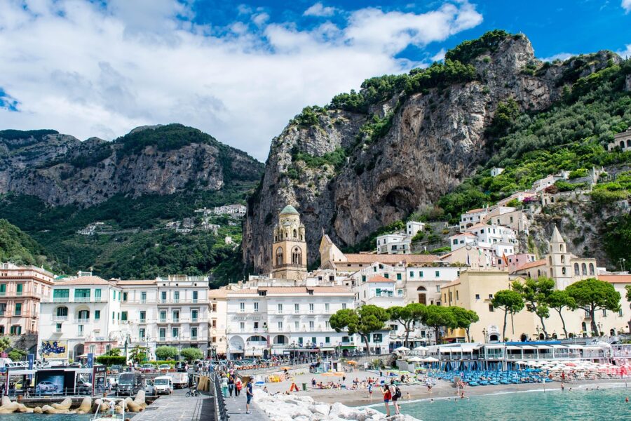 Amalfi Coast picturesque beach scene with cliffs, vibrant town, and Mediterranean architecture.